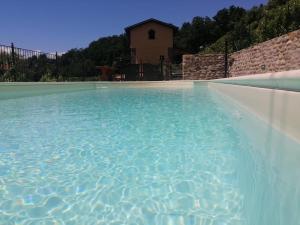 een zwembad met een huis op de achtergrond bij agriturismo il poderetto in Licciana Nardi