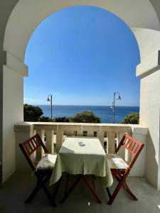 einen Tisch und zwei Stühle auf einem Balkon mit Meerblick in der Unterkunft Monolocali a Palazzo Rizzelli in Santa Cesarea Terme