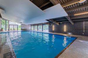 a large indoor swimming pool with blue water at Condo 2 chambres avec parc aquatique! in Beaupré