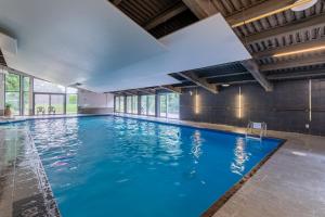 a large indoor swimming pool with blue water at Condo 2 chambres avec parc aquatique! in Beaupré