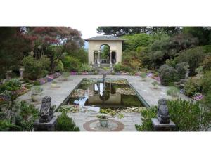 a garden with a fountain and a building in the background at Bru Na Pairc B&B in Bantry