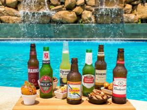 a group of beer bottles on a table next to a swimming pool at Salinas Maragogi All Inclusive Resort in Maragogi
