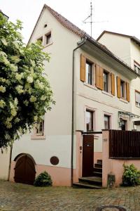a white house with orange shutters on it at Gemütliches Stadthaus im Herzen der Altstadt in Bad Dürkheim