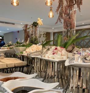 een buffet met gebak op tafels en stoelen bij Midan Hotel & Suites Al Aziziya in Mekka