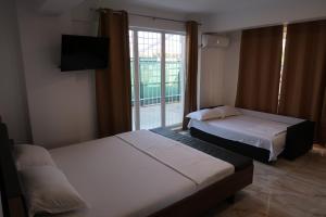 2 Betten in einem Hotelzimmer mit Fenster in der Unterkunft Home Space One in Mamaia Nord – Năvodari