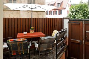 een tafel en stoelen op een patio met een parasol bij Gemütliches Stadthaus im Herzen der Altstadt in Bad Dürkheim