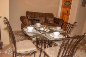 a dining room with a table with chairs and a couch at Bev's Rosevilla in Montego Bay