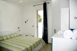 a bedroom with a bed with a striped blanket and a mirror at Palinuro Casa Vacanza Melita in Palinuro