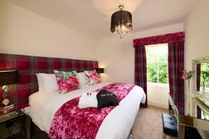 Un dormitorio con una cama grande y una ventana en Monkland Cottage, en Nairn