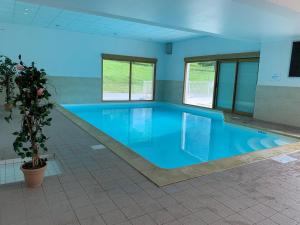 una gran piscina de agua azul en un edificio en AU COEUR DU GOLF **, Giez, proche Lac d' Annecy en Giez