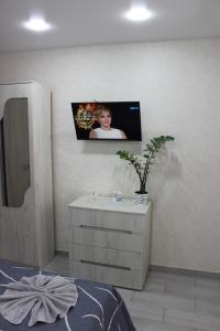 Cette chambre dispose d'une commode avec une photo sur le mur. dans l'établissement Apartments in Kharkiv, à Kharkov