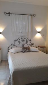 a bedroom with a white bed with a metal headboard at Pension Barbara in Katapola