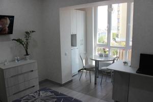 a kitchen and dining room with a table and a window at Apartments in Kharkiv in Kharkiv