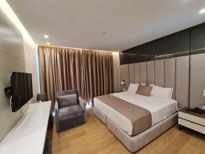 una stanza d'albergo con un letto e una sedia di Hotel Aross a Vlorë