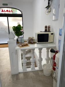 una mesa blanca con un microondas encima en Aloja Madrid, en Madrid 3 fotos más