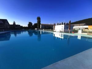 a large swimming pool with blue water at Apartmány Star in Kežmarok