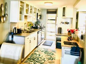 a kitchen with white cabinets and a rug on the floor at Fantastic Marina View in Front of My Window! in Los Angeles