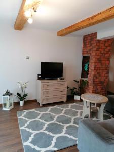 uma sala de estar com uma televisão, um sofá e uma mesa em Nocleg u Marysi em Iwonicz-Zdrój