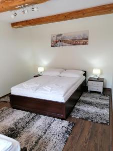 Nocleg u Marysi في إيفونيتش-زدروي: غرفة نوم بسرير مع شراشف بيضاء ومصباحين