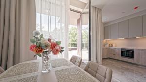 a vase of flowers on a table in a kitchen at Jūrmala, apartamenti Kruzes Nams in Jūrmala