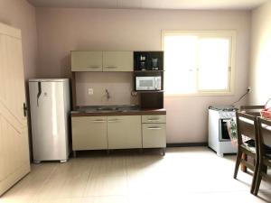 y cocina con nevera y microondas. en Casa no Vale dos Vinhedos en Bento Gonçalves