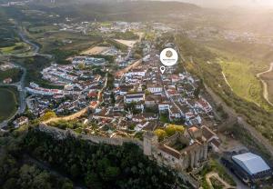 an aerial view of a town with a castle at Rainha Santa Isabel - Óbidos History Hotel in Óbidos
