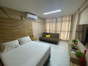 ein Hotelzimmer mit einem Bett und einem Sofa in der Unterkunft Edifício Time Apto 1101 ER Hospedagens in Maceió