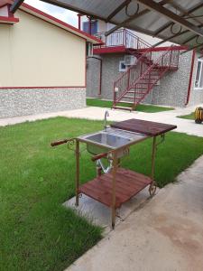 een metalen wastafel op een picknicktafel in een tuin bij Guest House Valiland in Bŭlgarevo