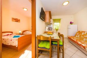a room with a bed and a kitchen with a table at Apartment Vrsi at the Beach in Vrsi