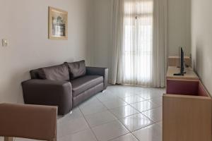 a living room with a couch and a television at Hotel Sagres Praia in Balneário Camboriú