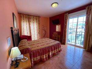 sypialnia z łóżkiem i dużym oknem w obiekcie Quéntar Hotel Rural w mieście Quéntar