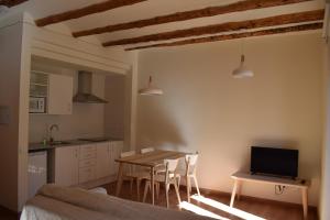 Apartaments Casa el Metge في Prat de Comte: مطبخ وغرفة طعام مع طاولة وكراسي