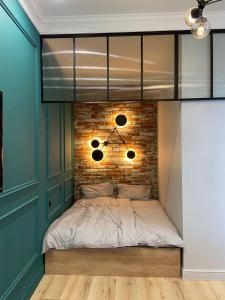 een bed in een kamer met een bakstenen muur bij Lux appartments в центре города в стиле Loft in Vinnytsya