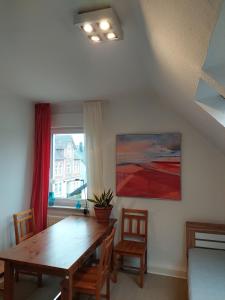 a dining room with a wooden table and a window at Turmzimmer in Bielefeld