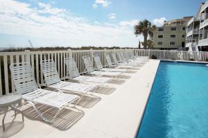 a row of lounge chairs on a balcony with a pool at Laguna Keyes 707 in Myrtle Beach