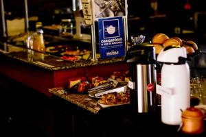 a counter with plates of food and a water bottle at Pousada do Xerife in Caconde