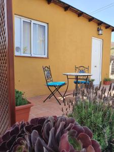 un patio con 2 sillas y una mesa frente a una casa en Casa Leyla, en Vilaflor