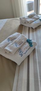 drei weiße Handtücher auf zwei Betten in der Unterkunft LA BELLA DIMORA in Otranto