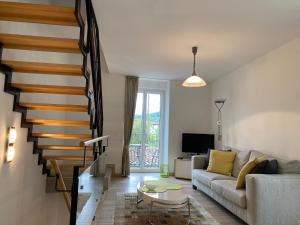 un soggiorno con divano e una scala di Rustico San Giorgio: Losone a Losone