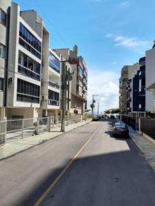 eine Straße mit einem an der Seite eines Gebäudes geparkten Auto in der Unterkunft Apartamento amplo em meia praia - poucos metros do mar in Itapema