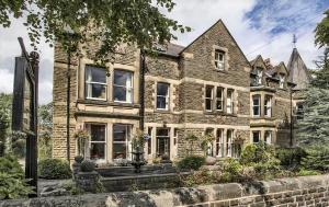 a large brick house with a yard at Kingscroft in Buxton