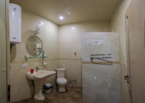 a bathroom with a sink and a toilet and a mirror at Отель центр Трускавца in Truskavets +25 photos