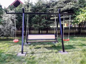 a swing in a yard with two swings at Zakątek nad Sanem, Załuż 128 in Załuż