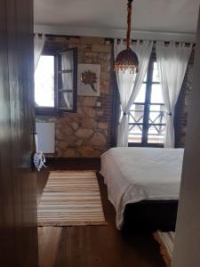 a bedroom with a bed and a window at ANASTASIA STONE HOUSE in Psakoudia