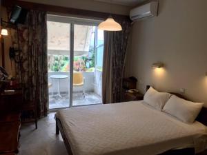 una camera con letto e finestra con tavolo di Batis Hotel a Livanates