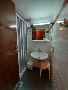 Baño pequeño con lavabo y espejo en Batis Hotel, en Livanates