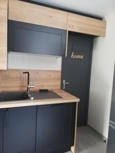 a kitchen with a sink and a door with home written on it at La casa d'Ernestine in Colmar