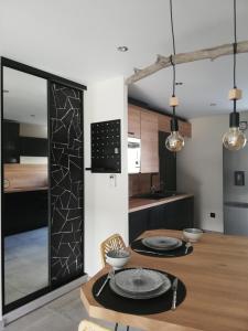 uma cozinha e sala de jantar com uma mesa de madeira e uma sala de jantar em La casa d'Ernestine em Colmar