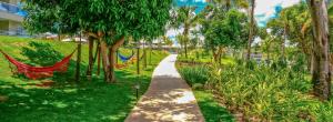 einen Weg durch einen Park mit Bäumen und einer Hängematte in der Unterkunft ILHAS DO LAGO ECO RESORT in Caldas Novas