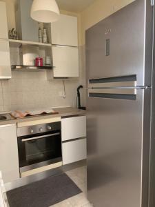 a kitchen with a stainless steel refrigerator and white cabinets at Appartamento in Villa a Policoro in Policoro